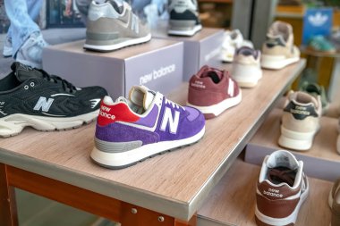 Özel bir mağazada yeni denge ayakkabıları. NB logosu olan çeşitli marka ayakkabılar..