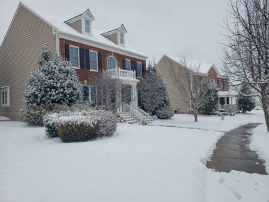 Kar yağışı ve tipiden sonra kar Leesburg, Virginia 'nın evlerinde ve ağaçlarında yatar..