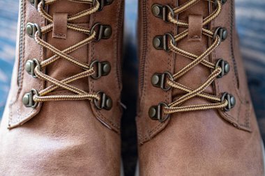 Kahverengi deri çizmelerde danteller ve metal perçinler. Sıradan şehir ayakkabıları. Yakın plan..