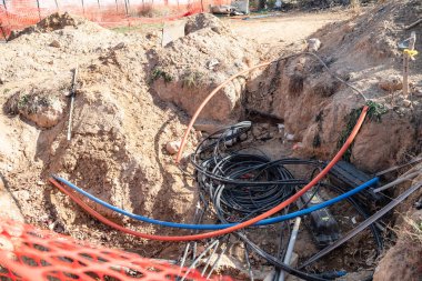 İnşaat veya onarım alanındaki bir çukurun elektrik kablolarını ve kablolarını kesin..