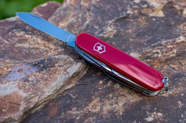 Victorinox Spartan İsviçre çakısını taştan arka planda katlıyor