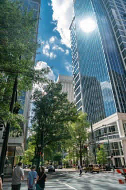 Charlotte İş Merkezi. Yüksek binalar, bulutları yansıtan cam cepheler..