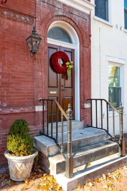 Geleneksel Noel çelengi tuğla evin ön kapısında..