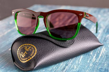 Rayban marka logolu Ray-Ban güneş gözlüğü ve deri çanta..
