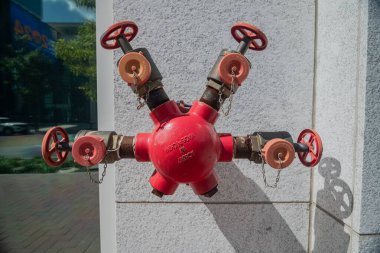 Modern binanın granit duvarında kırmızı yangın musluğu.