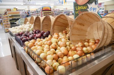 Süpermarket tezgahında beyaz, kırmızı ve sarı soğanlar.