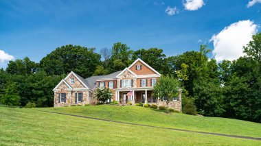 Yazın yeşil ağaçları ve güzel manzarası olan lüks bir ev..