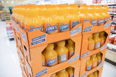 Süpermarkette plastik şişelerde güneşli D portakal suyu.