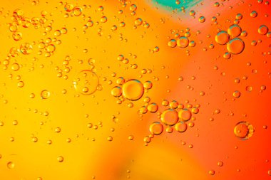 Parlak renkli arka planda yüzen yağ kabarcıkları. Makro çekim.