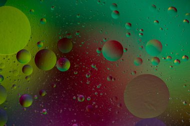 Oil and water abstract background. Oil bubbles floating on a colored background. clipart