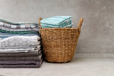 Temiz havlularla dolu bir sepet ve masanın üzerinde bir yığın mutfak havlusu. Boşluğu kopyala.