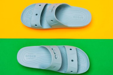 Ayırt edici bir tasarımı olan bir çift mavi Crocs sandalet.