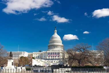 ABD Başkenti kışın Washington 'da. Mavi gökyüzü ve kubbenin üzerindeki bulutlarla şehir manzarası.