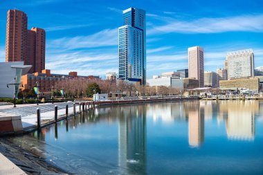 Baltimore 'un modern binalarıyla donmuş liman ve şehir manzarası. Donmuş suda yansıma.