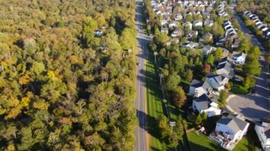 Sonbahar ormanlarında gün batımında köy ve kasaba havadan izleniyor, Washington banliyösünde konut evleri, villalar, yollar ile uçuyor.