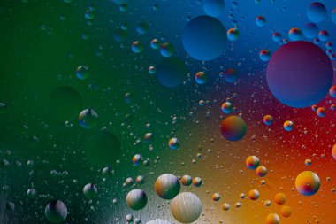 Mavi-kırmızı-sarı arka planda yüzen yağ damlaları. Bilimsel araştırmalar soyut.