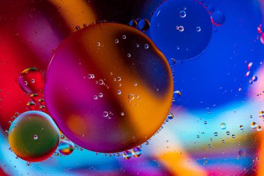 Mavi-kırmızı-sarı arka planda yüzen yağ damlaları.