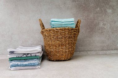 Temiz havlularla dolu bir sepet ve masanın üzerinde bir yığın mutfak havlusu. Boşluğu kopyala.