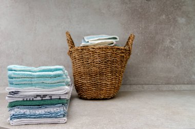 Bir yığın temiz mutfak renkli havlu ve hasır sepet. Boşluğu kopyala.