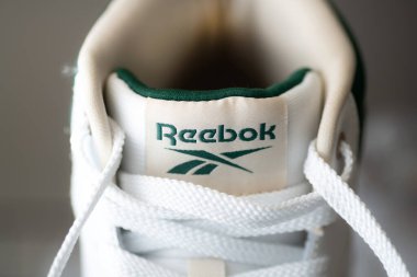 Beyaz spor ayakkabıların üzerindeki Reebok logosunun yakın çekimi.