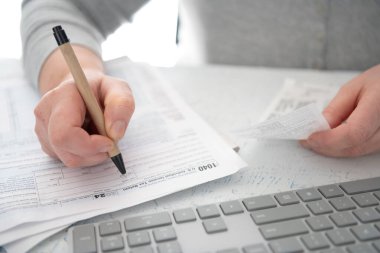 Kadın finansal hesaplamalar yapmak için hesap makinesi kullanıyor ya da t dosyası dolduruyor