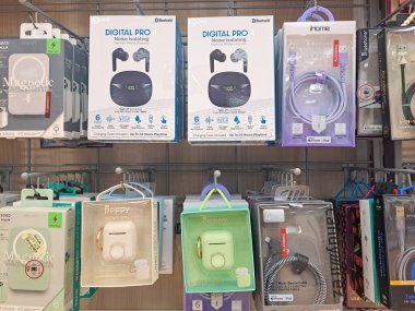 Süpermarket raflarında Bluetooth kulaklıklar ve cep telefonu aksesuarları.