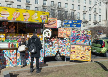 Müşteriler, Washington DC 'deki bir binanın önündeki minibüsün sahibinden yiyecek satın alıyor..