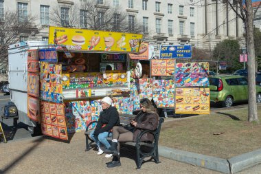 Minibüsün duvarlarında renkli etiketler ve reklamlar olan sokak yemekleri kamyonu..