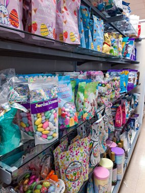 Paskalya için rafları eşyalarla doldurun. Çikolatalı Paskalya tavşanları, yumurtalar ve diğer tatlılar