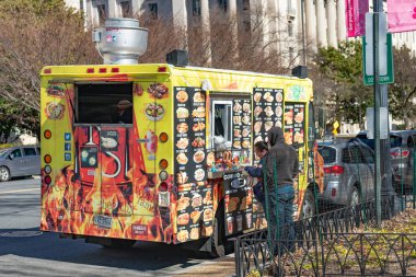 Bir erkek ve bir kadın Washington, DC 'de yol kenarındaki bir yemek kamyonundan yemek alıyorlar..
