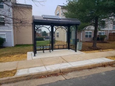 İçinde bank olan yeni cam ve metal otobüs durağı.