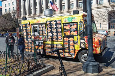 Bir erkek ve bir kadın Washington, DC 'de yol kenarındaki bir yemek kamyonundan yemek alıyorlar..