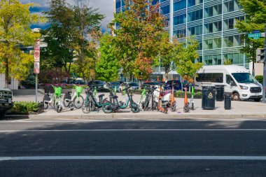 Elektrikli bisikletler ve elektrikli scooterlar şehir yolundaki otoparkta..