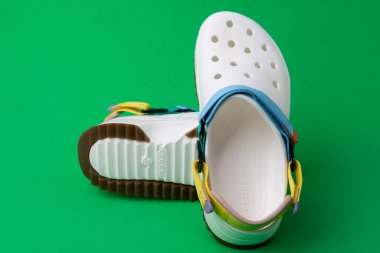 Yeşil arka planda renkli kayışları olan rahat timsah sandaletleri.