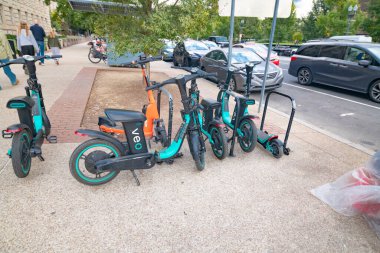 Elektrikli bisikletler ve elektrikli scooterlar şehir yolundaki otoparkta..