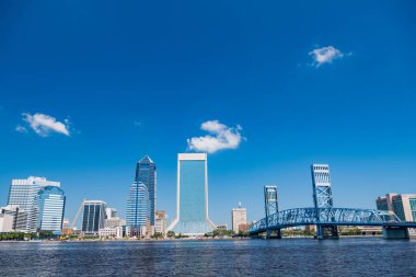 Jacksonville Florida 'daki iş merkezinin gökdelenleri üzerinde mavi gökyüzü ve ana caddedeki köprü