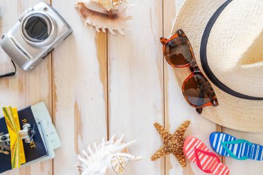 Şapkadan, mermilerden, kameradan ve pasaportlu uçaktan yapılmış yaz çerçevesi. Beyaz tahta arkaplan.