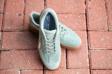 Kaldırım fayansında Reebok klasik kraliyet yeşil spor ayakkabıları.