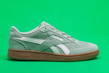 Yeşil arka planda yürümek ve koşmak için Reebok hafif spor ayakkabıları.