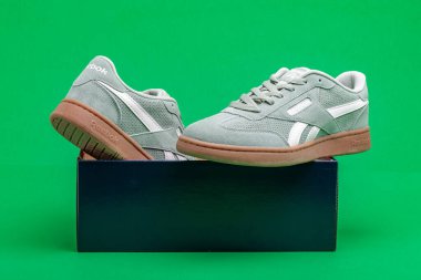 Spor ayakkabıları yeşil arka plandaki kutuda Reebok.