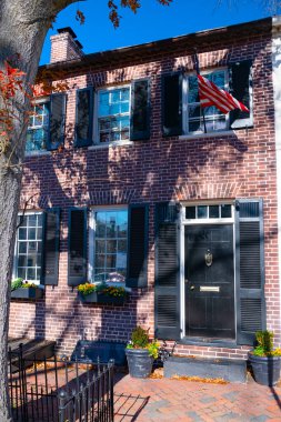 Çekici görünüşlü eski tuğla ev, panjurlu siyah kapı. Tuğlalı kaldırım.