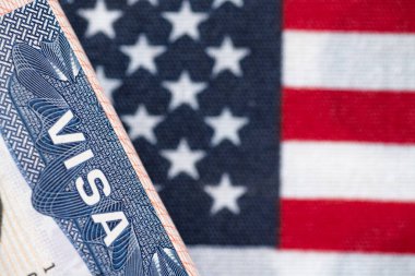Birleşik Devletler bayrağı ve Birleşik Devletler vizesi. Göçmenlik ve Amerika Birleşik Devletleri 'ne seyahat kavramı. Amerikan bayrağının arka planındaki pasaportta vize var..