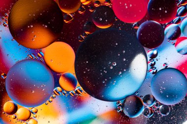 Turuncu ve mor renkli karışık su ve yağın renkli soyut arkaplanı. Renkli kabarcıklar