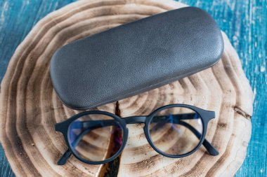 Ahşap kütüğün üzerinde gözlüklü şeffaf optik gözlük..