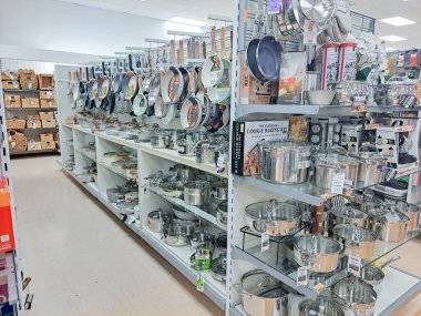 Cam kapaklı paslanmaz çelik tencereler ve raflarda kızartma tavaları..