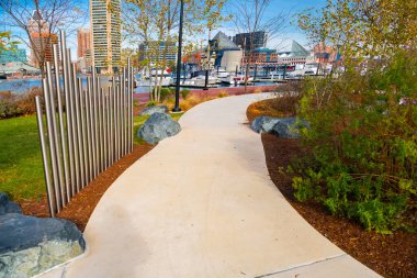 Baltimore 'un iç liman bölgesindeki rıhtımda yürüyüş yolları. Peyzaj tasarımı, banklar ve oturma alanları.