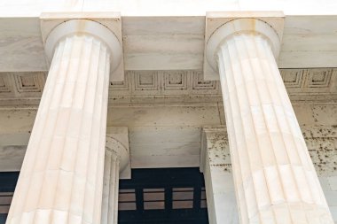 Zarif beyaz sütunları olan bir bina. Aşağıdan görüntüle.