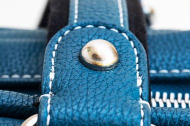 Tokaların, kopçaların, bağlayıcıların, donanımın ve mavi deri çantanın üzerine dikişlerin yakın plan görüntüleri.