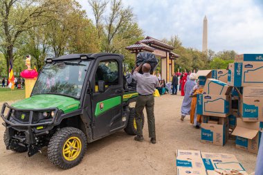 Erkek çöp toplayıcısı plastik çöp torbalarını elektrikli bir kamyona yüklüyor. Washington 'da çöp toplama.