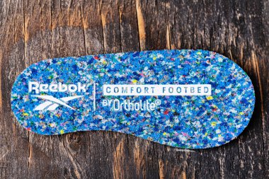 Spor ayakkabılarının yumuşak tabanındaki Reebok logosuna yakın plan..